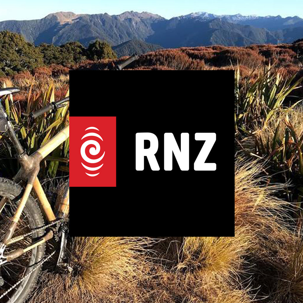 RNZ logo over a bamboo mountain bike in golden tussock grass with mountains behind