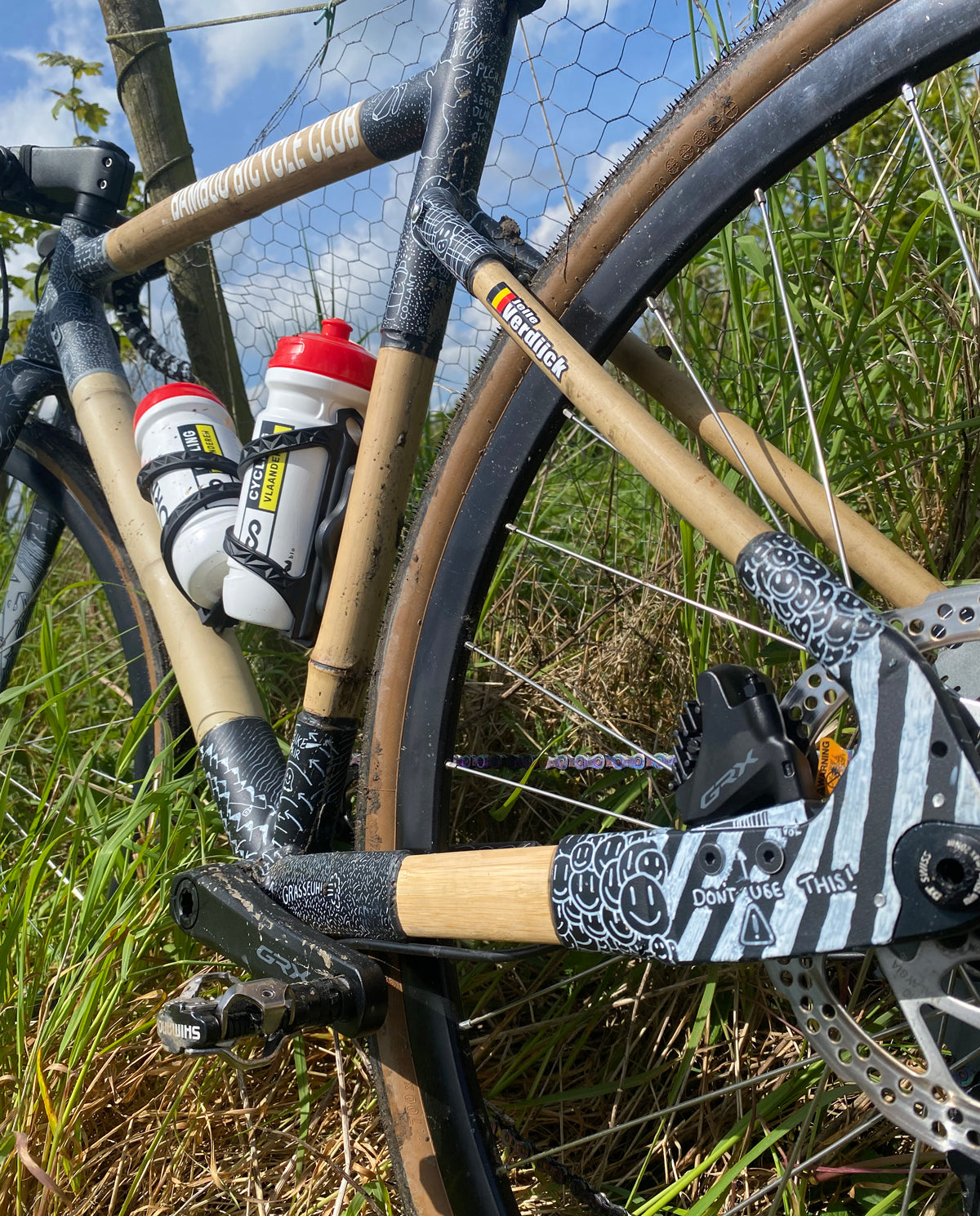Close-up of Jelle's bamboo gravel bike showing hand-doodled black and white joints and two bottles