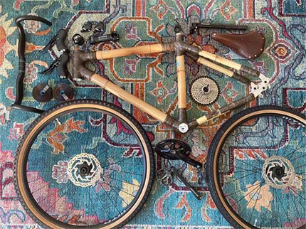 Gabriel's bamboo gravel frame, wheels and components laid out on a patterned rug