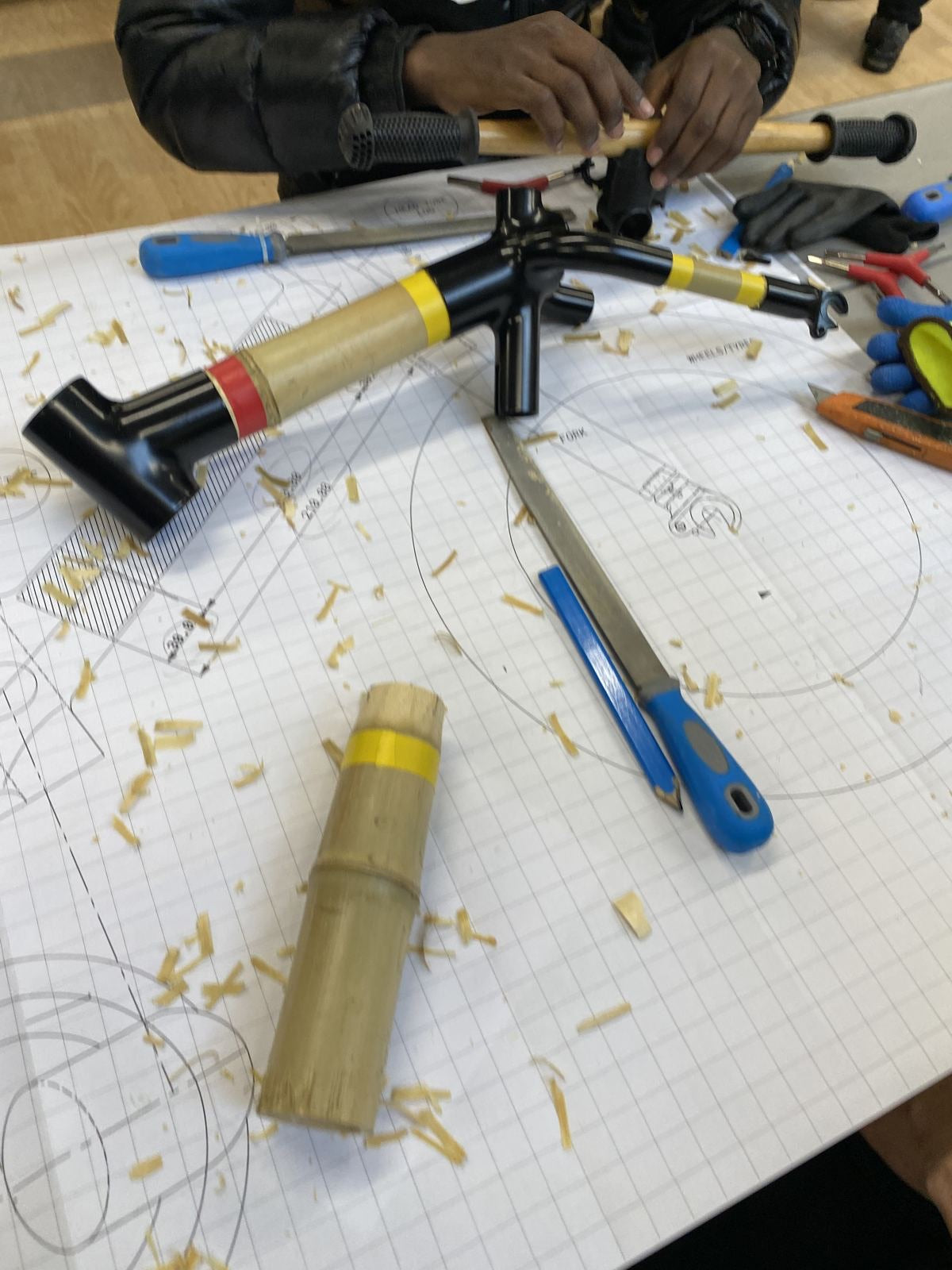 Hands shaping a bamboo frame on the jig
